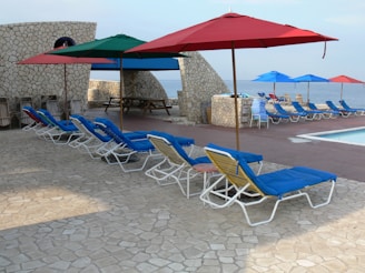 Swimming pool area with lounge chairs and shaded seating.