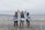 4 women standing on beach during daytime