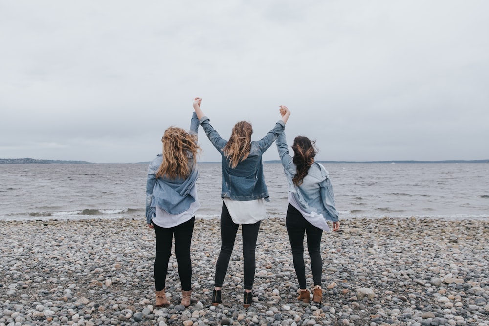 4 mujeres de pie en la playa durante el día