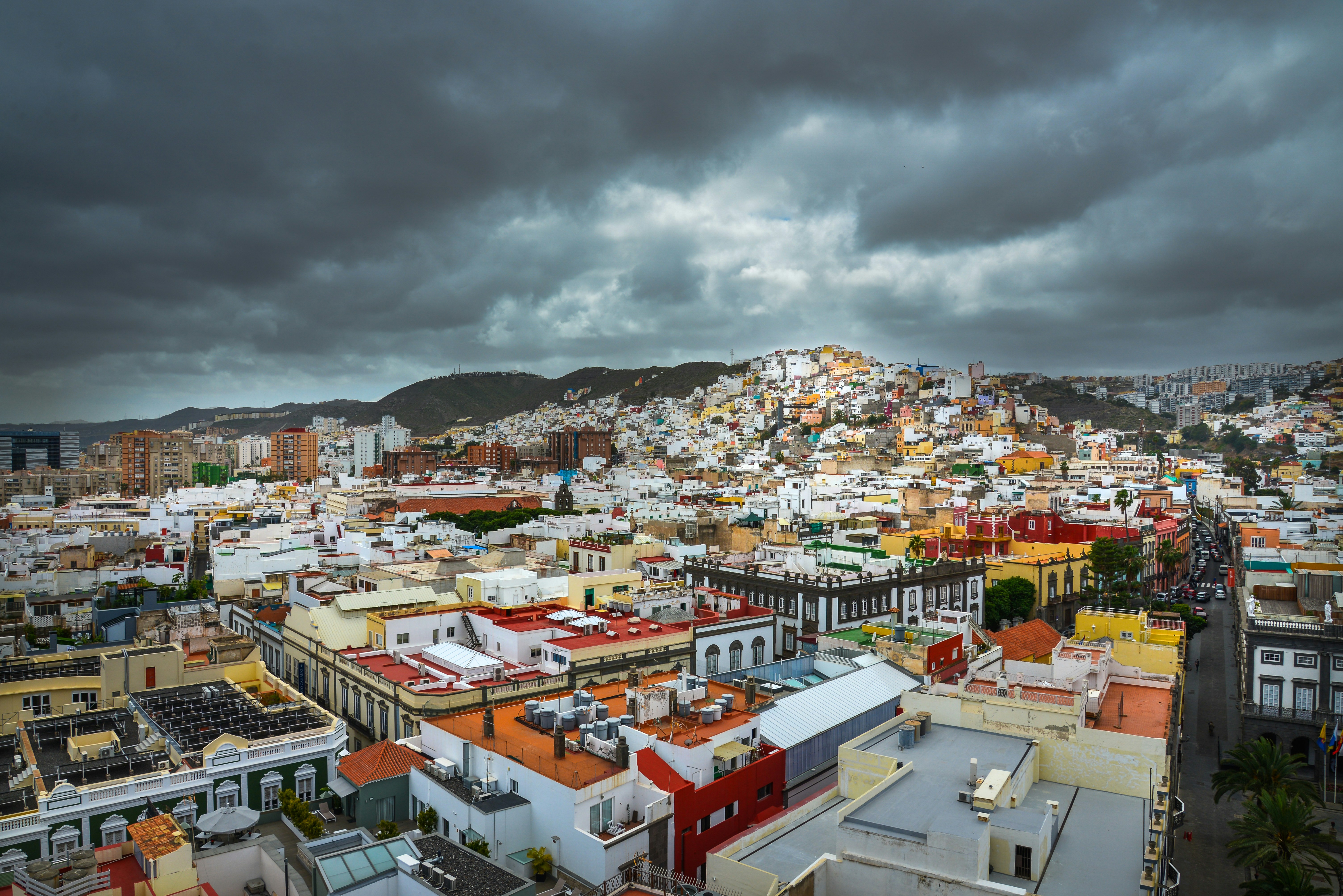 city with high rise buildings under gray clouds during daytime
