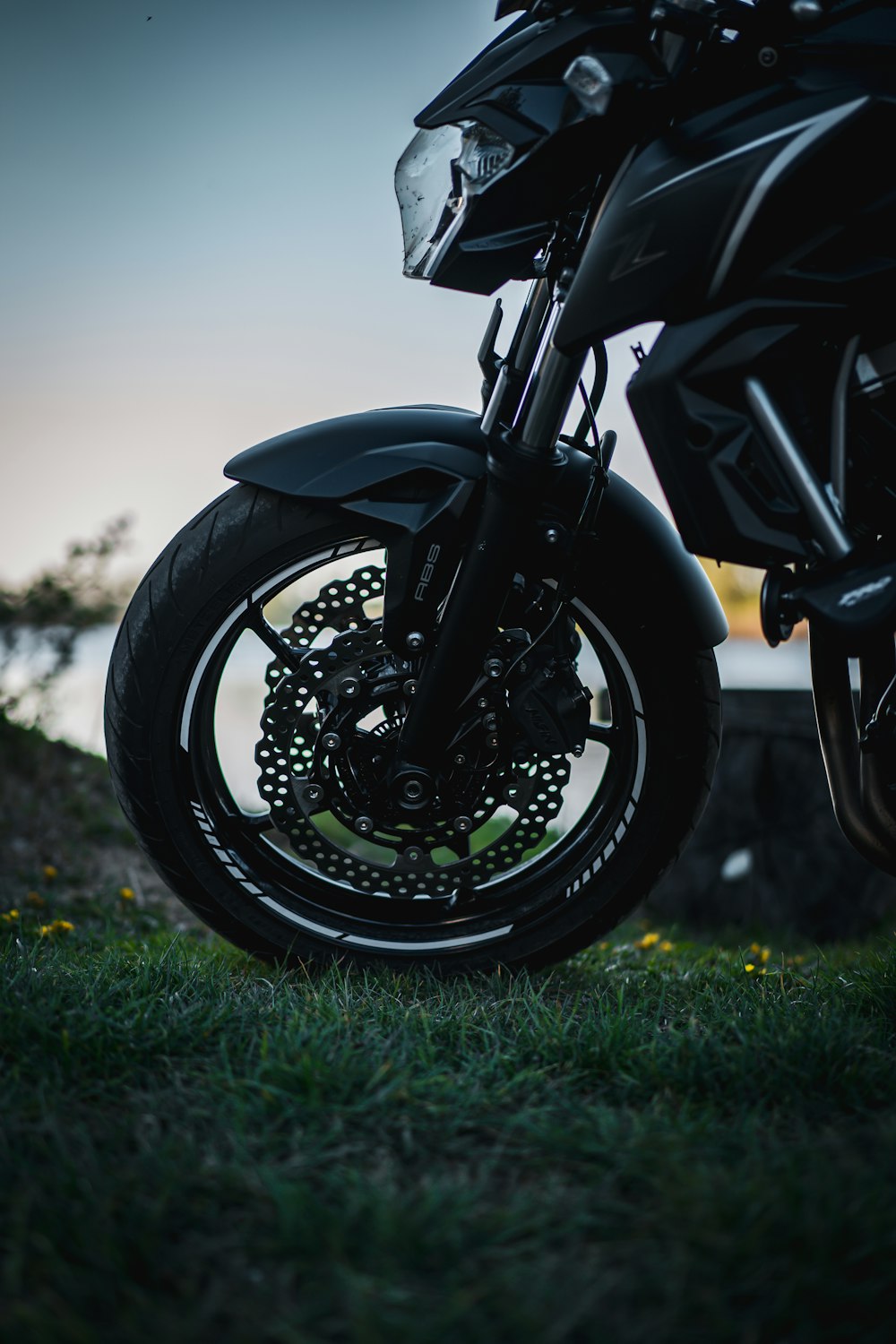 black motorcycle on green grass field during daytime