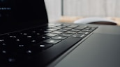 Close-up of hands typing on a sleek keyboard with soft shadows and rounded elements in the background.