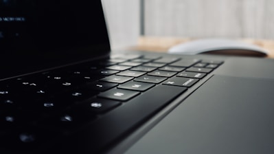 Close-up of hands typing on a sleek laptop keyboard with digital interface overlay