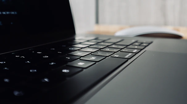 Close-up of a Microsoft Surfer 4 laptop keyboard with a blurred background of a modern workspace.