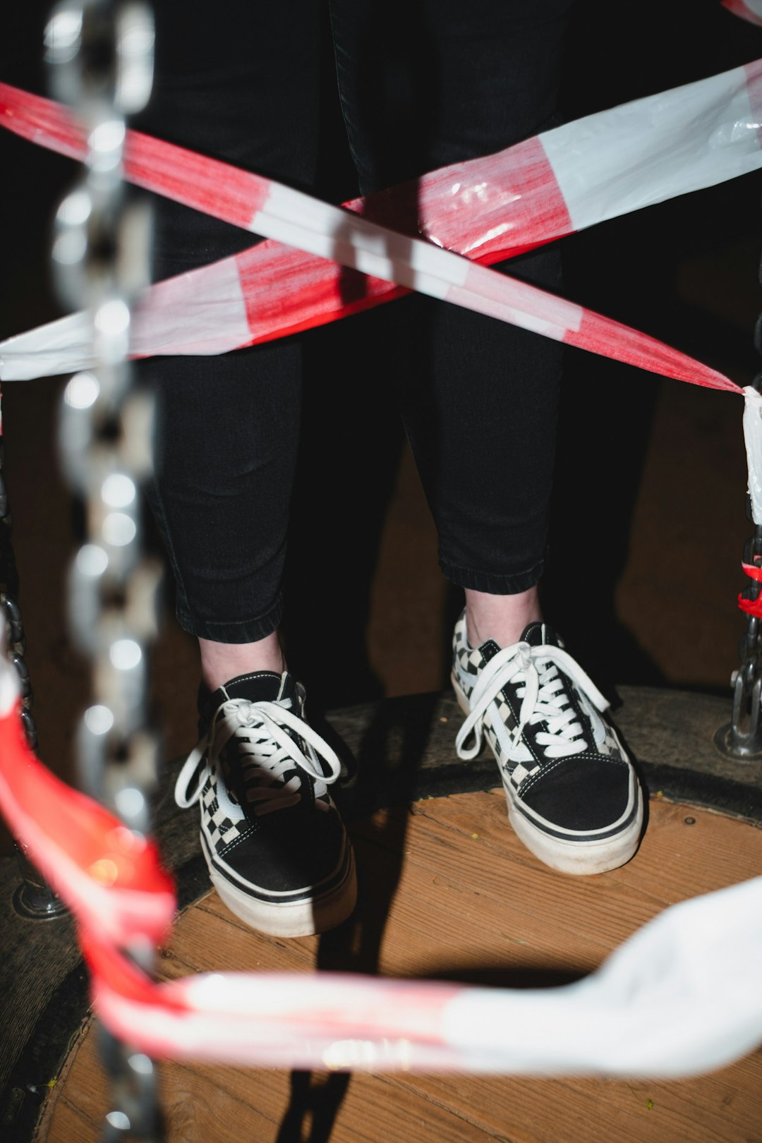 person in black pants and black and white sneakers