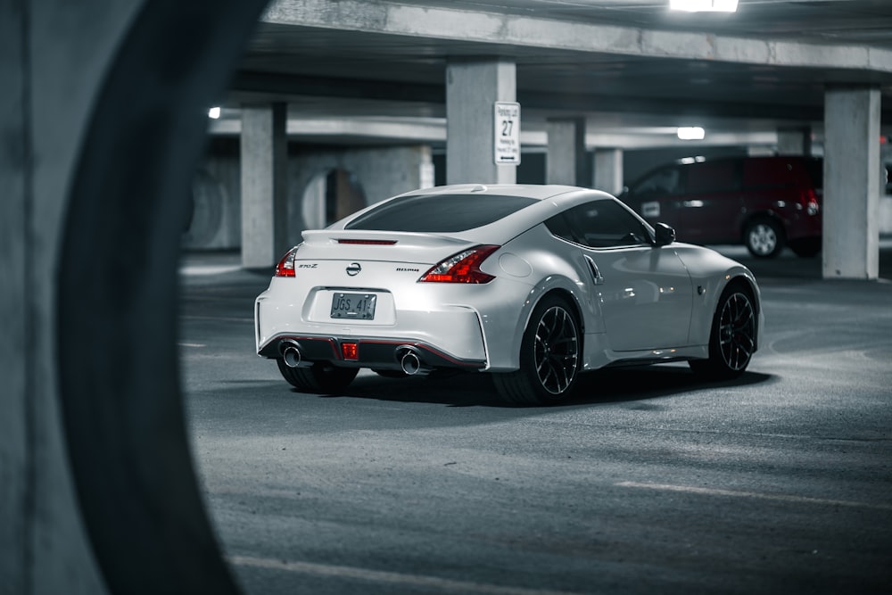 a white sports car parked in a parking garage