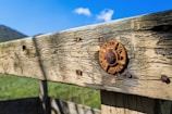 Close-up of a freshly repaired wooden fence with silver and blue tools resting nearby.