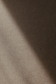 A textured fabric surface with diagonal lighting that creates a gradient of shadows and highlights across the material.