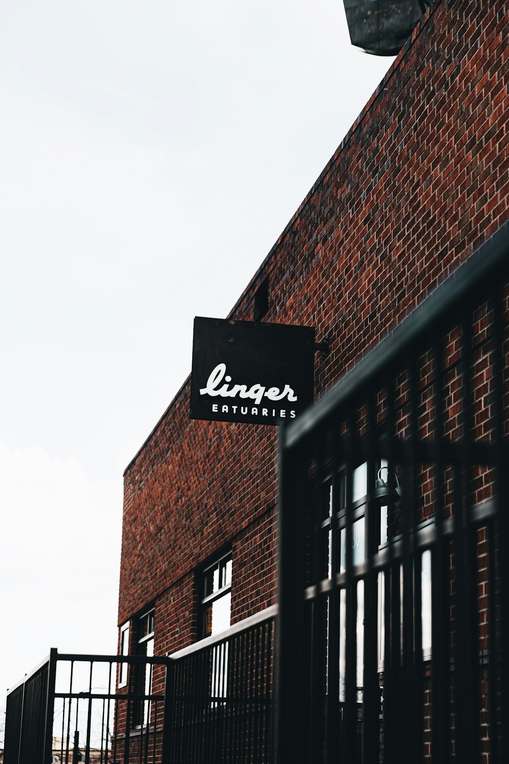 brown brick building with black metal gate