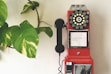 red and black telephone on white wall