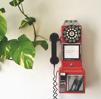 red and black telephone on white wall