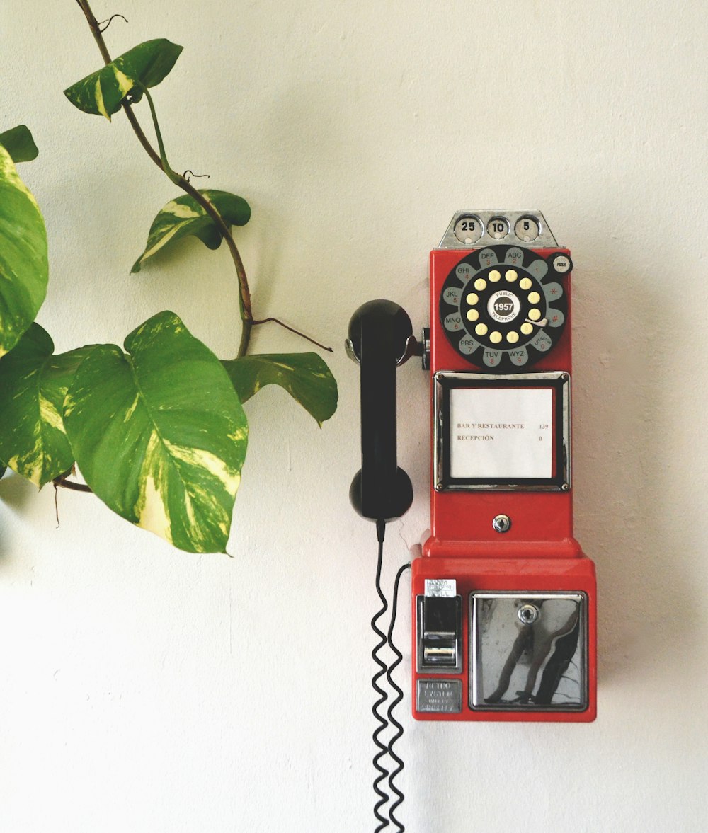 red and black telephone on white wall