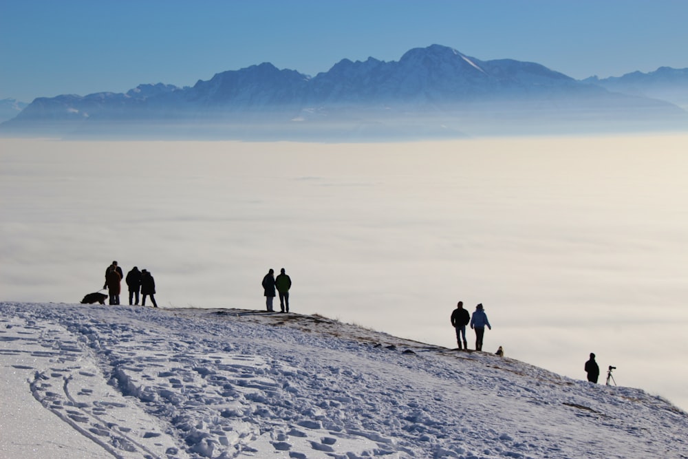 Silueta de personas que caminan sobre el suelo cubierto de nieve durante el día