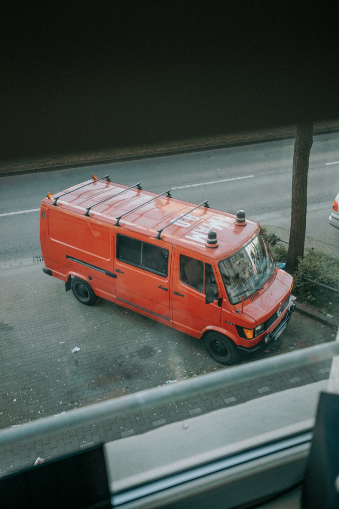 red van on gray asphalt road during daytime