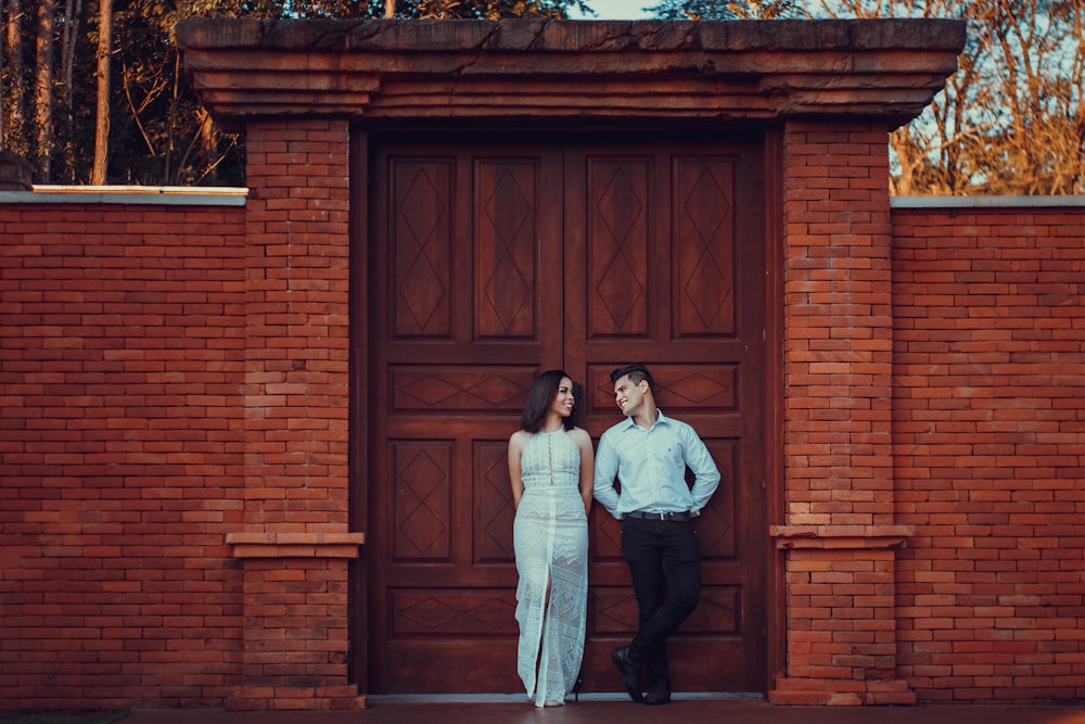 couple standing beside brown wooden door