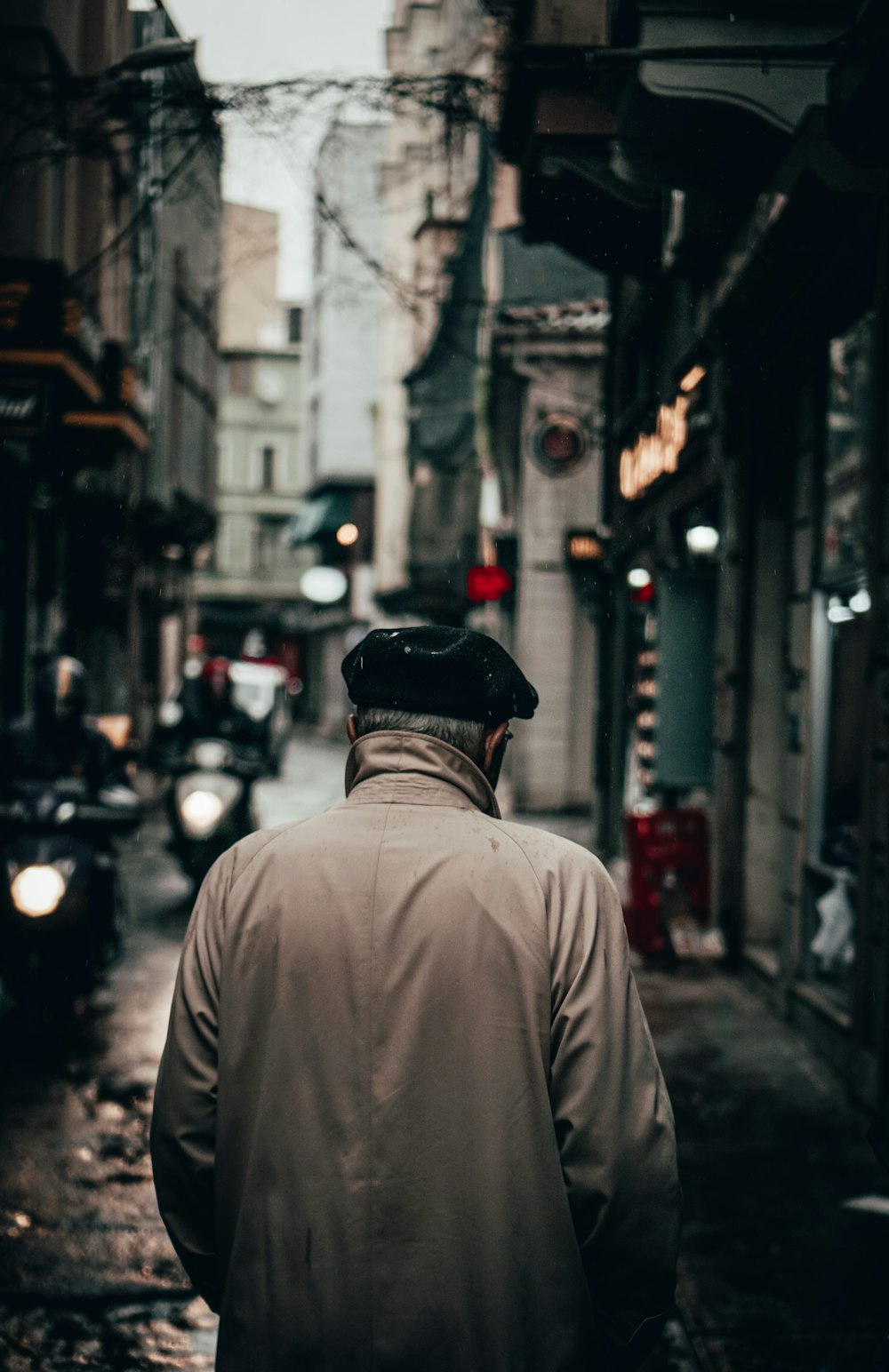 Mann in braunem Hemd und schwarzem Hut geht tagsüber auf der Straße spazieren