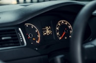 Close view of a vehicle dashboard lit by diagnostic equipment highlighting a sensor issue being resolved.