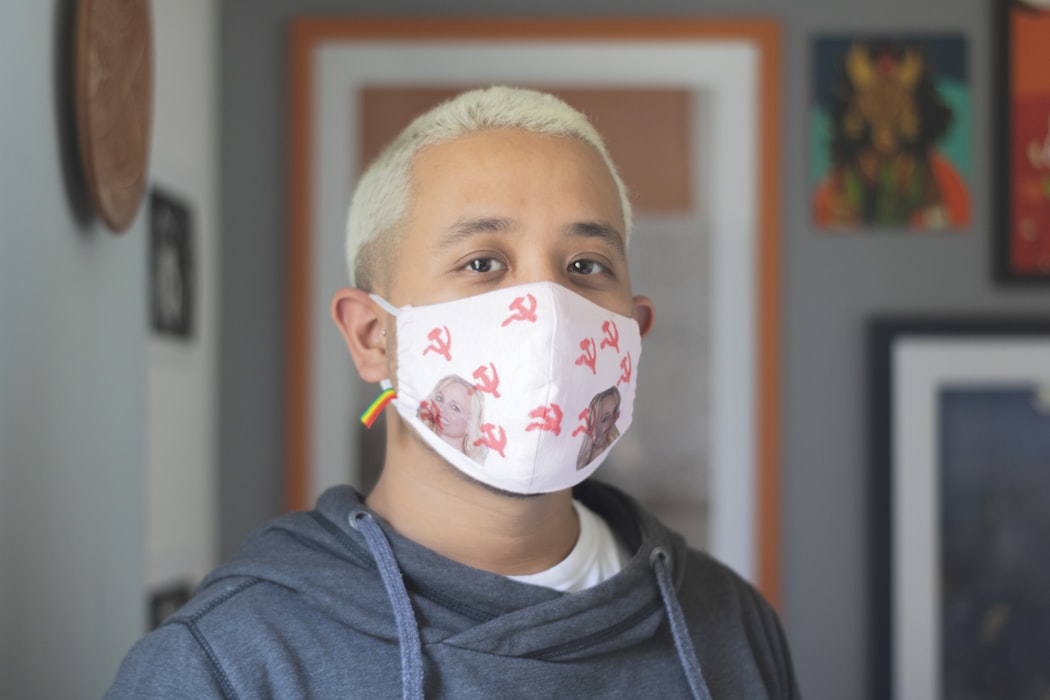 man in gray hoodie with white and yellow face mask