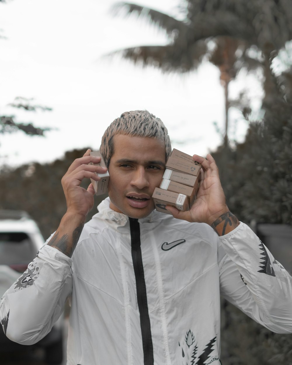 man in white dress shirt holding brown and white box