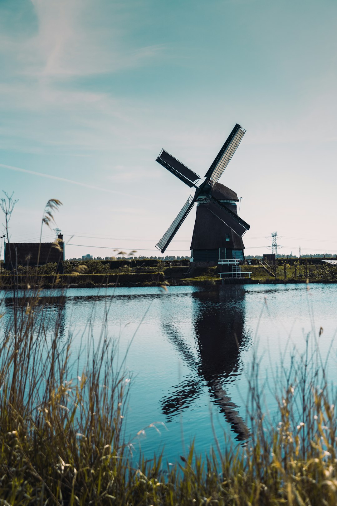windmill near body of water during daytime