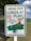 A sign displays the message 'HEALTHY LUNGS AT PLAY' in large green letters, with a no-smoking symbol and a smaller text indicating 'This is a tobacco-free zone.' It includes a cartoon illustration of children playing on a seesaw in a park setting.