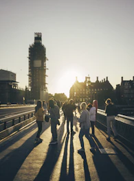 A team of engineers inspecting a large concrete bridge under construction at sunset.