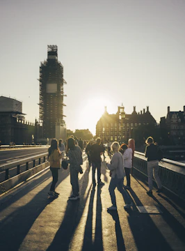 A team of engineers inspecting a large concrete bridge under construction at sunset.