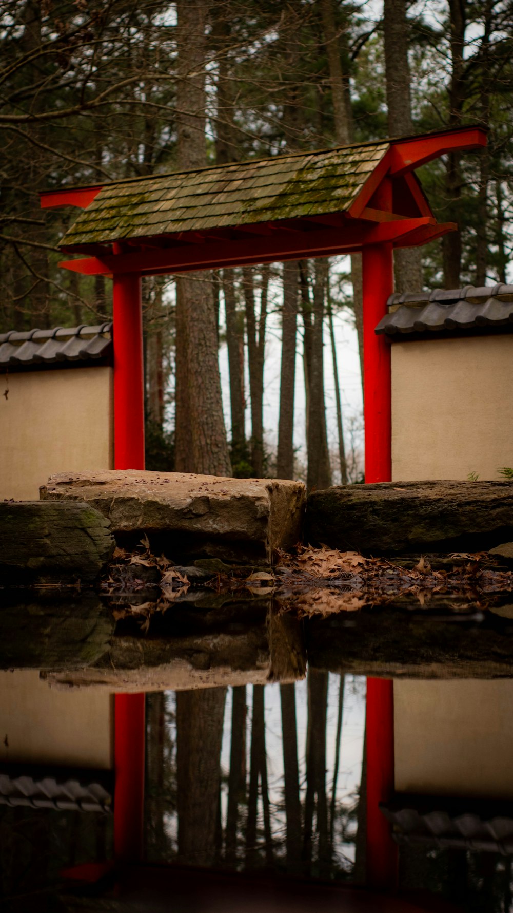 a red and white building sitting in the middle of a forest