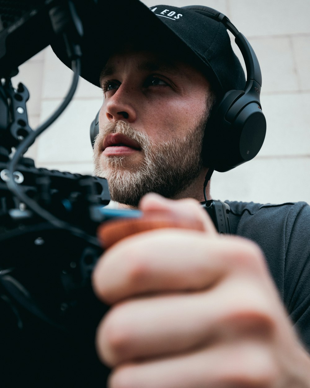 man in grey shirt wearing black headphones