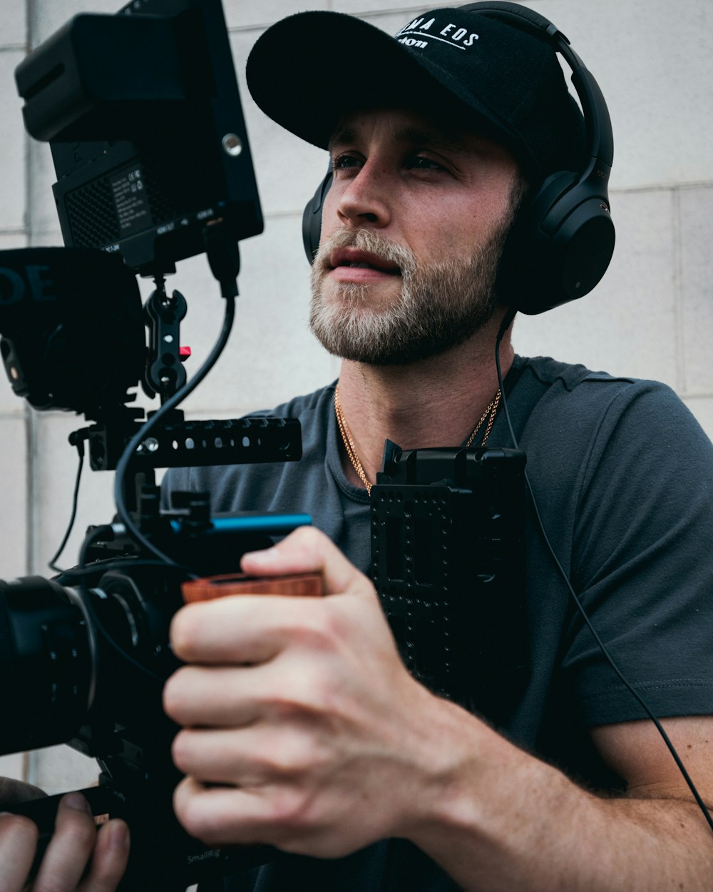 man in black crew neck t-shirt holding black dslr camera