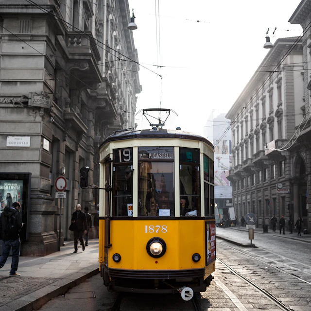 Yellow and white tram on a Milan street during the day