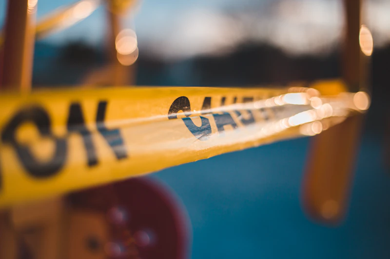 Yellow caution tape strung diagonally across a blurred background