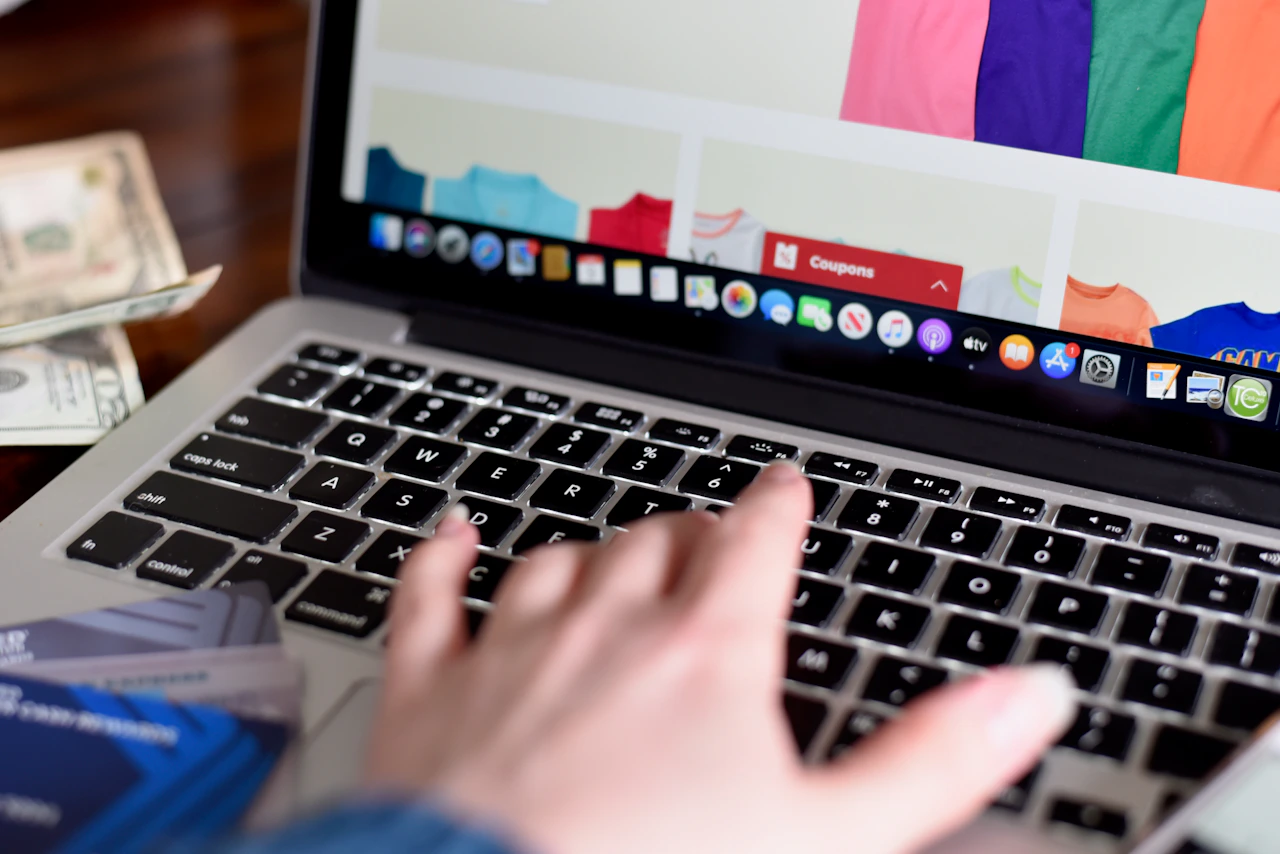 Hands typing on a laptop keyboard while working on a digital product.