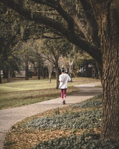 A calm morning jogger running through a green park trail.