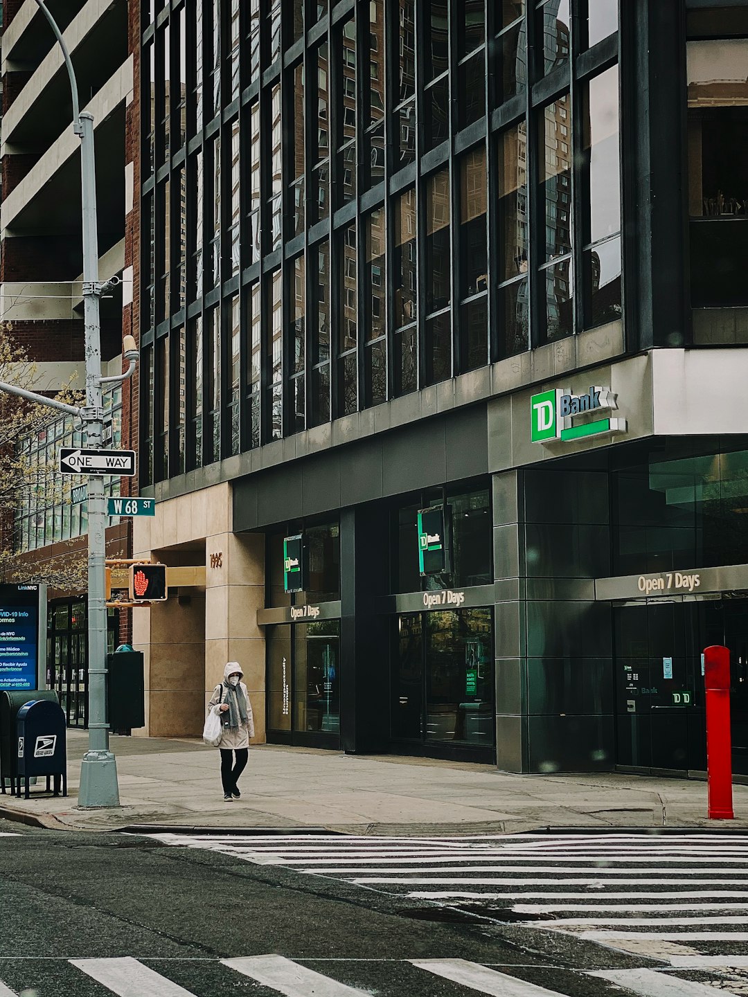 woman in black coat walking on sidewalk near building during daytime