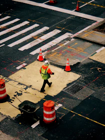 Engineer inspecting a busy intersection with safety cones and signage.