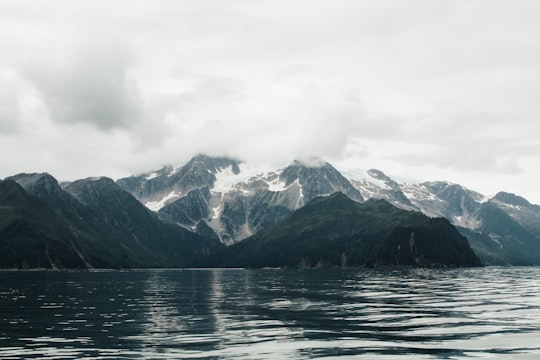snow covered mountain near body of water during daytime in Alaska United States