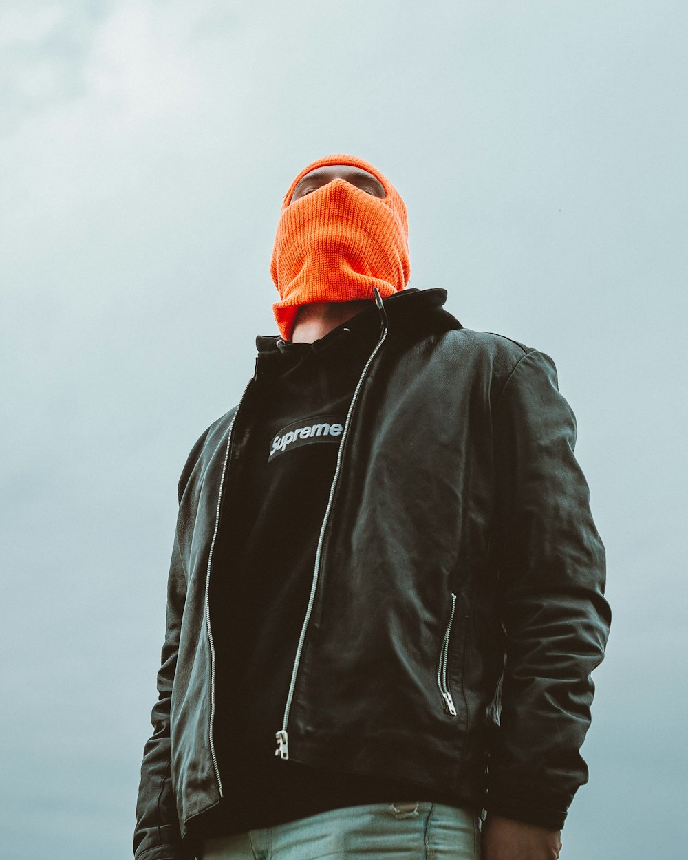 man in black jacket and orange knit cap