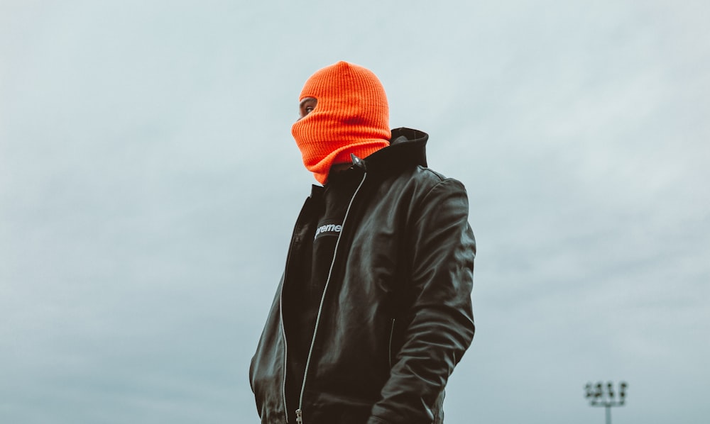 Herren in schwarzer Lederjacke und orangefarbener Strickmütze