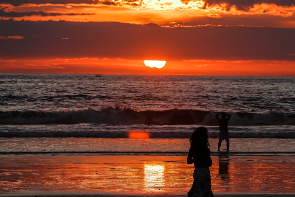 Silhouette von Menschen am Strand während des Sonnenuntergangs