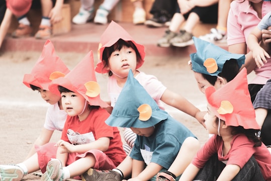 girl in pink shirt and blue shorts sitting on floor with girl in pink shirt