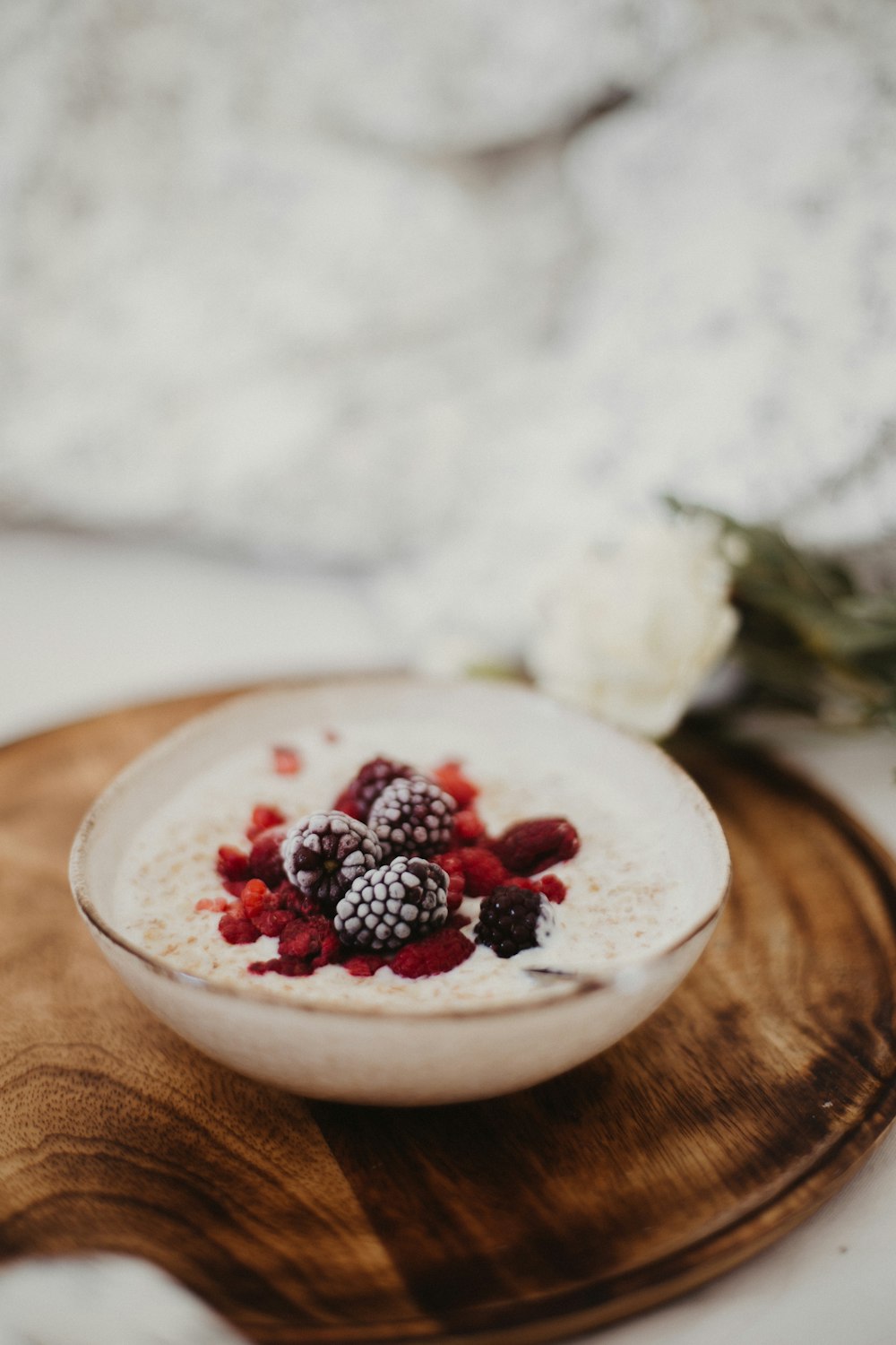 red and black berries on white ceramic bowl