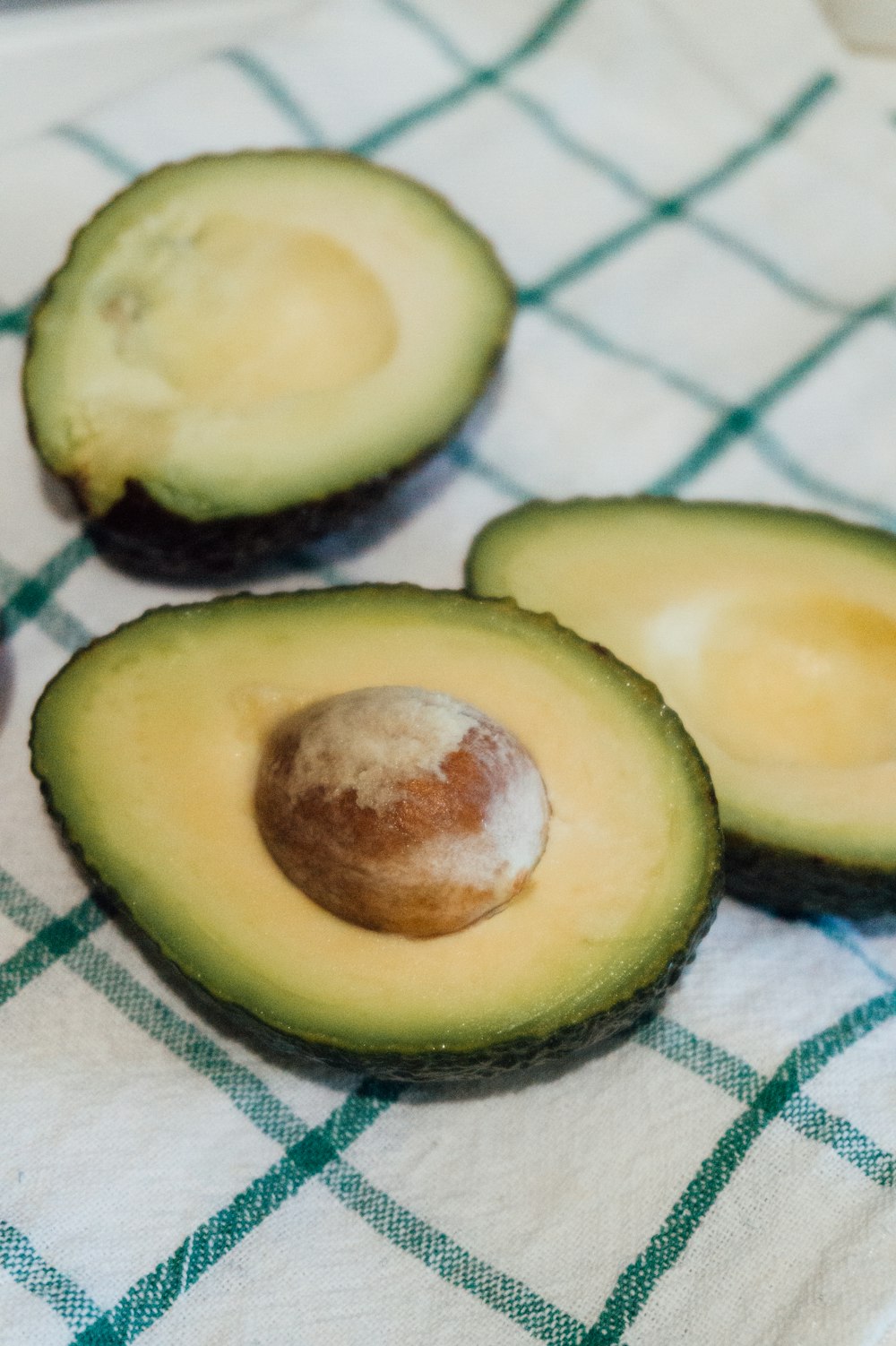 sliced avocado fruit on white and blue checkered textile