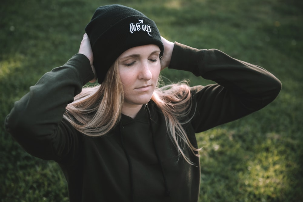 woman in black jacket wearing black cap smiling