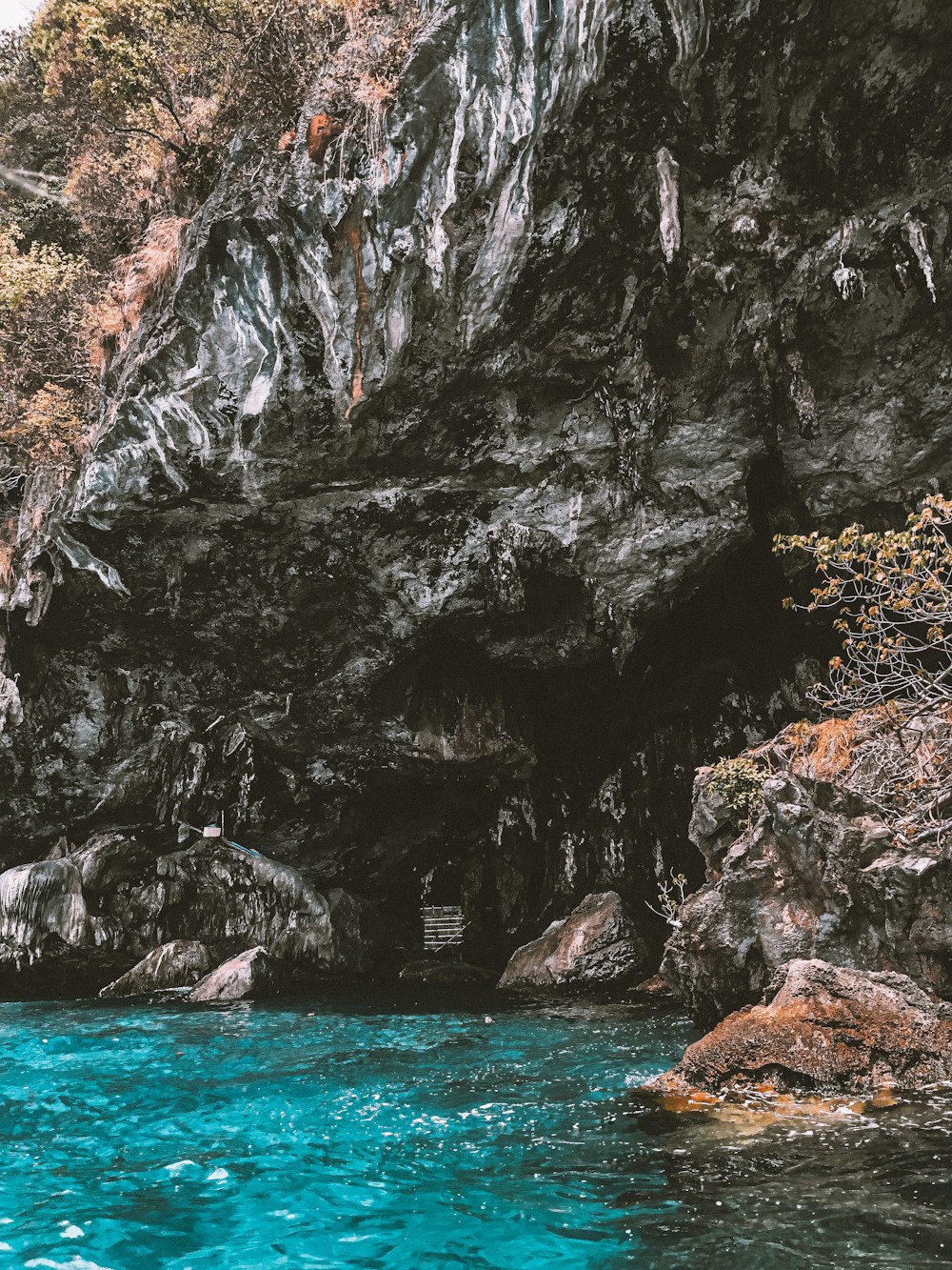 brown rocky mountain beside body of water during daytime