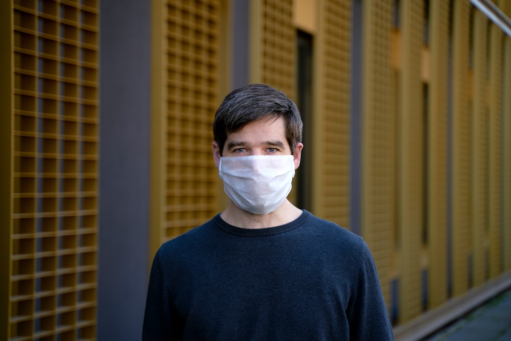 man in black crew neck shirt with white mask