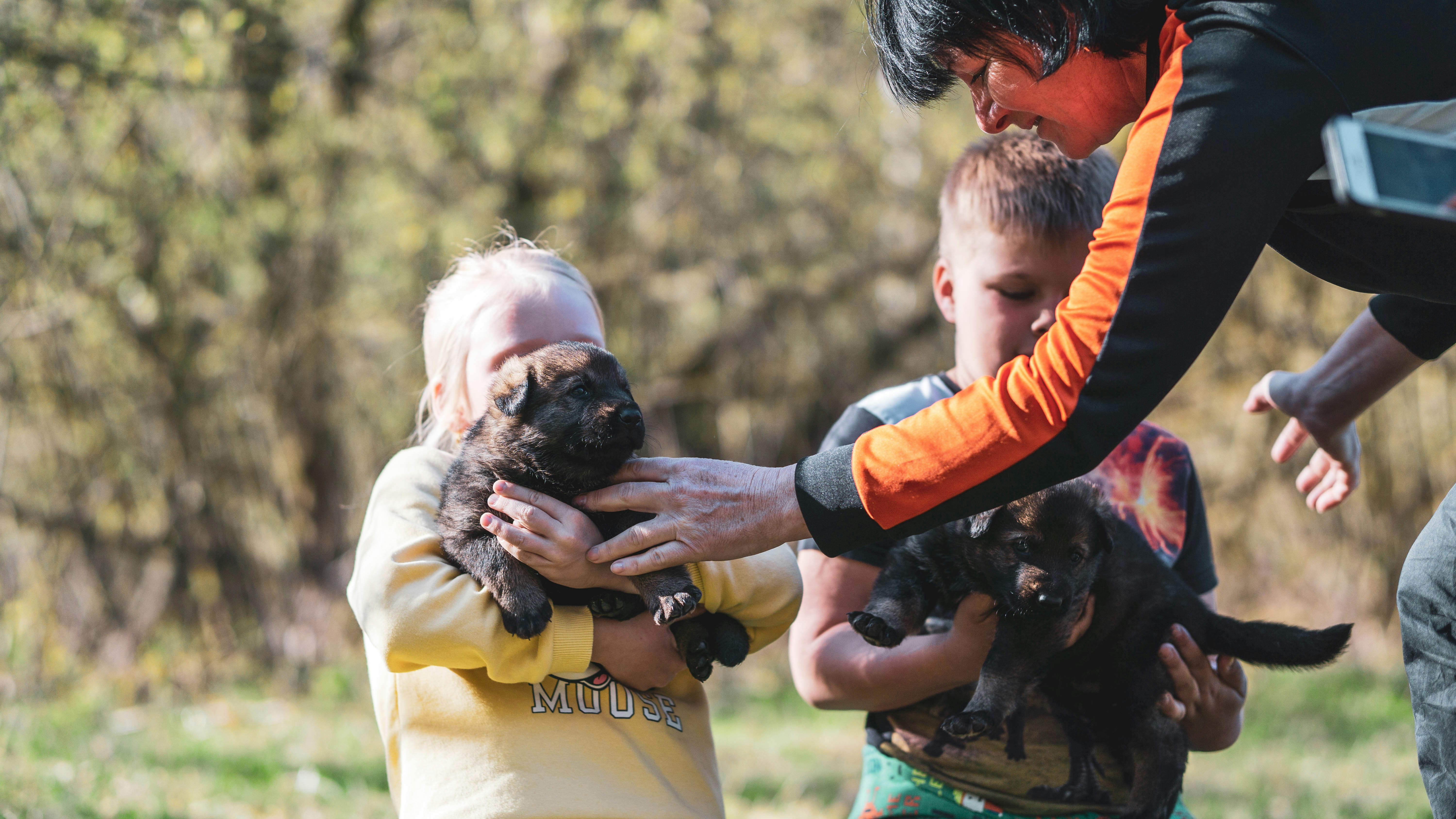 Man carrying black puppy