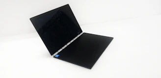 A sleek, modern laptop displaying the Menace Mobile Explained homepage with the Dr. Evil commercial video paused.