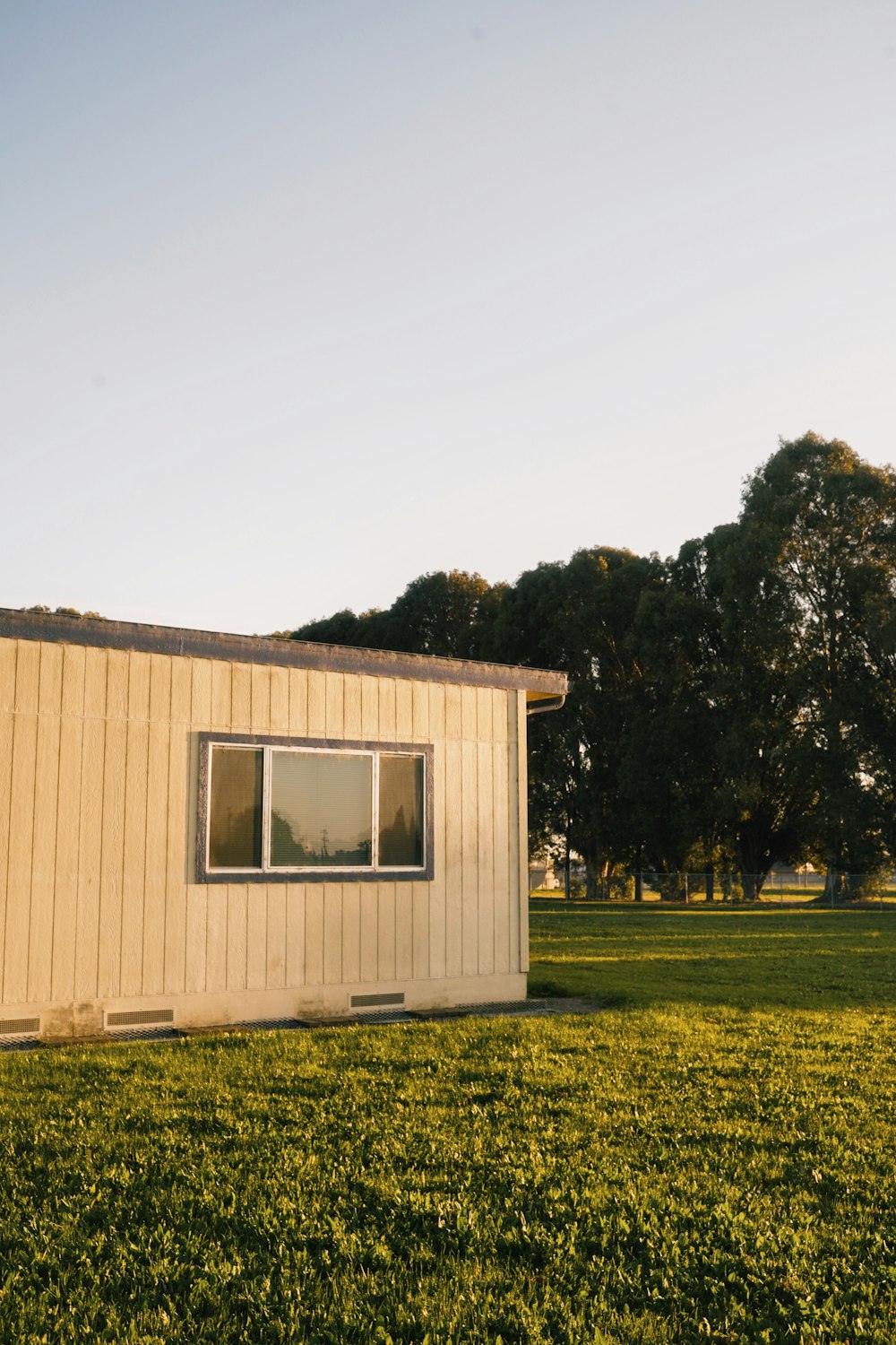 white and brown wooden house near green trees during daytime