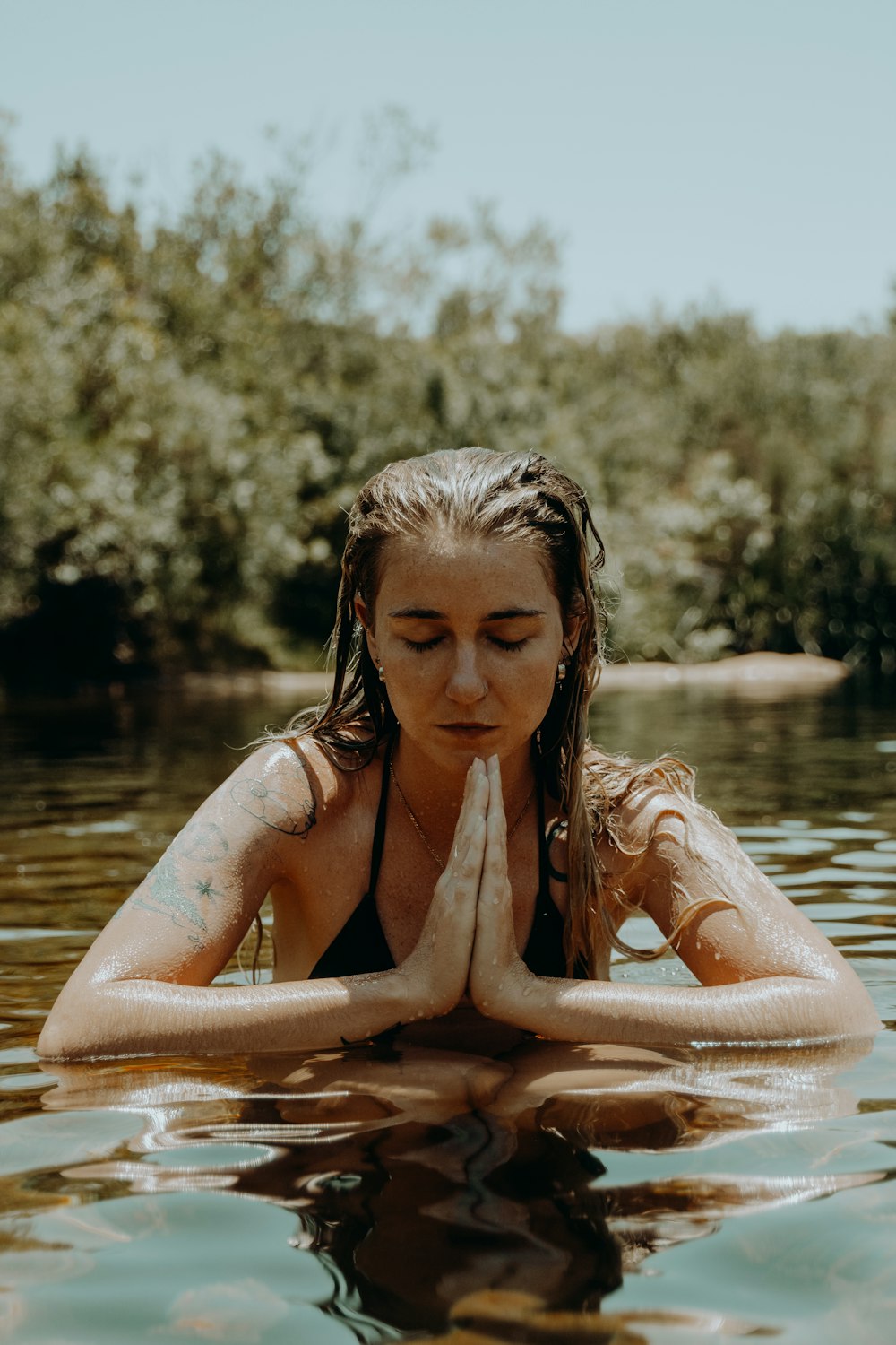 woman in black bikini top on water during daytime